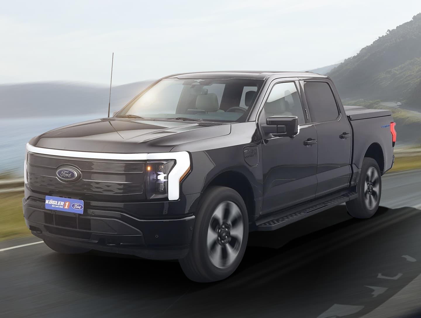 Ford Pickup in Seitenansicht, auf einer Straße mit Landschaft im Hintergrund