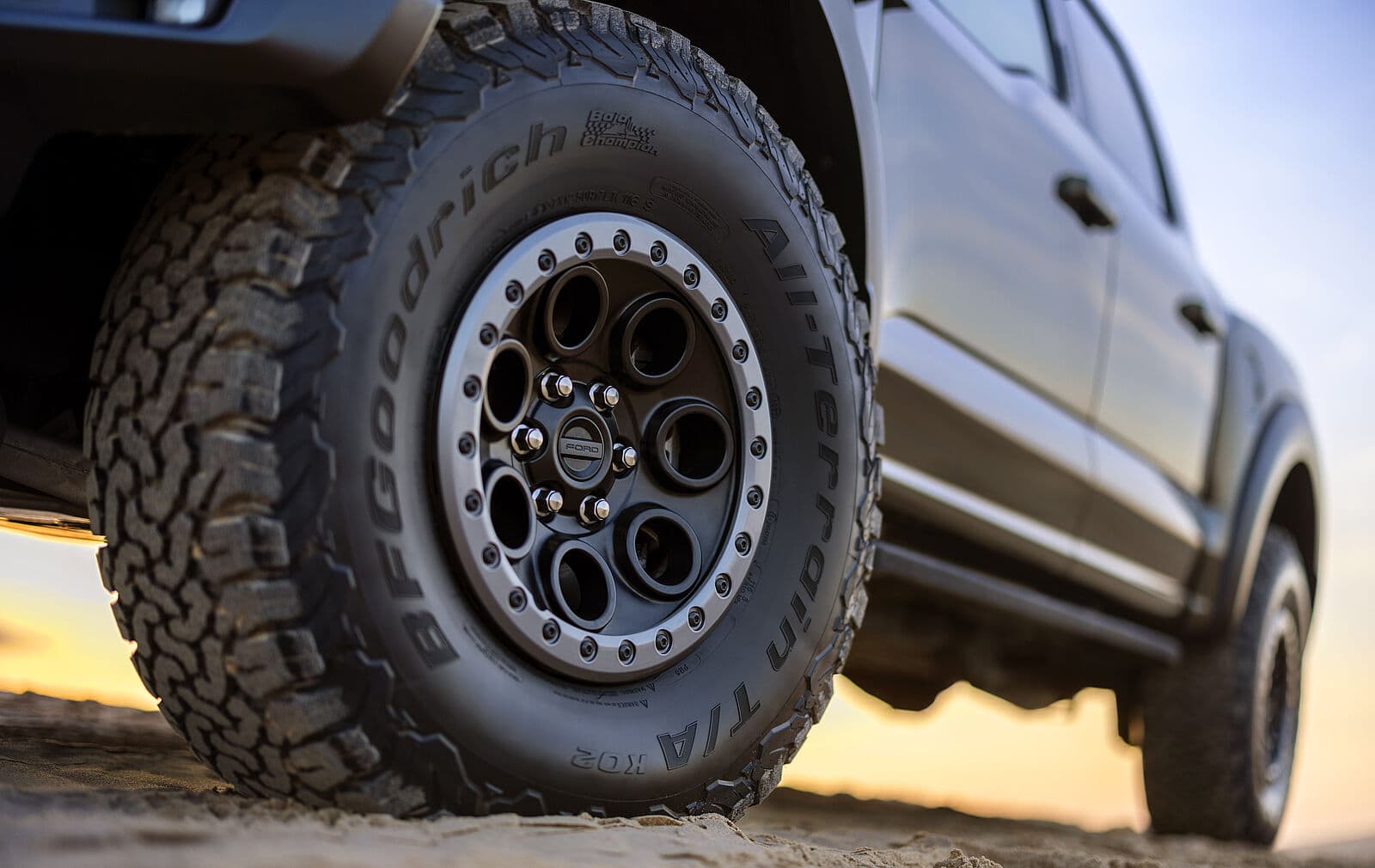 Nahaufnahme eines Ford F-150 Reifens mit markantem Profil und Felge im Sand