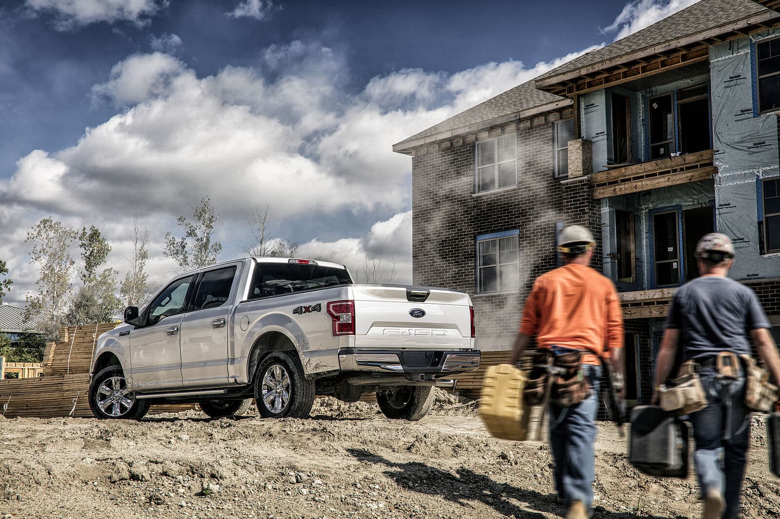 Ford F-150 in Seitenansicht auf einer Baustelle, mit Bauarbeitern im Hintergrund
