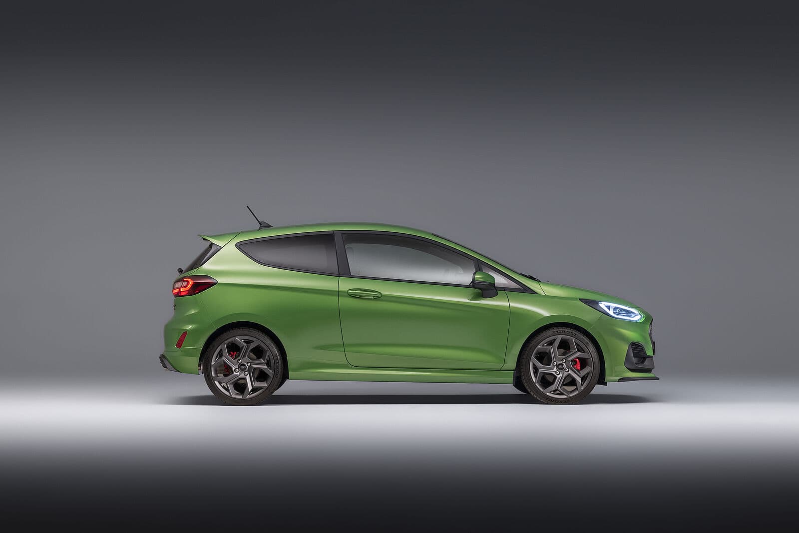 Seitenansicht eines grünen Ford PKW mit sportlichen Felgen vor neutralem Hintergrund