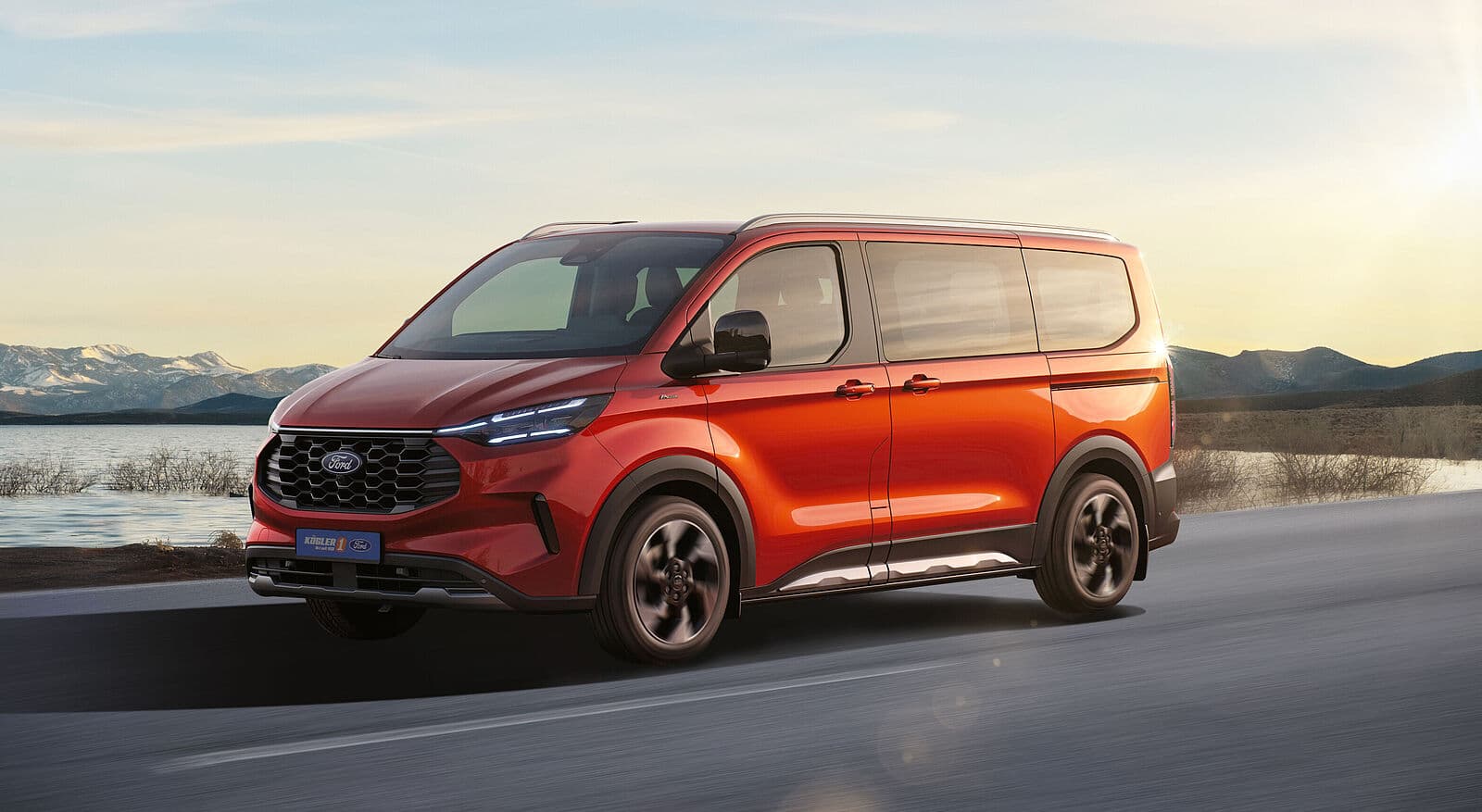 Ford Tourneo Custom in Rot, Seitenansicht auf einer Straße mit Berglandschaft im Hintergrund