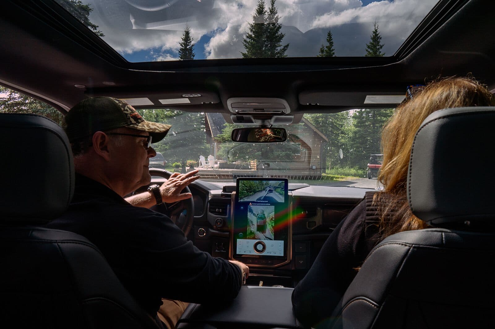 Innenansicht des Ford F-150 mit zwei Personen, großem Touchscreen und Blick auf die Umgebung