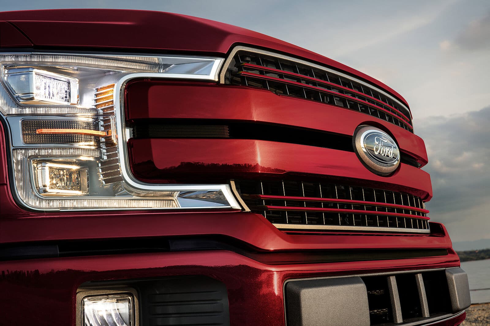 Nahaufnahme der Frontpartie eines roten Ford F-150 mit sichtbaren Scheinwerfern und Kühlergrill